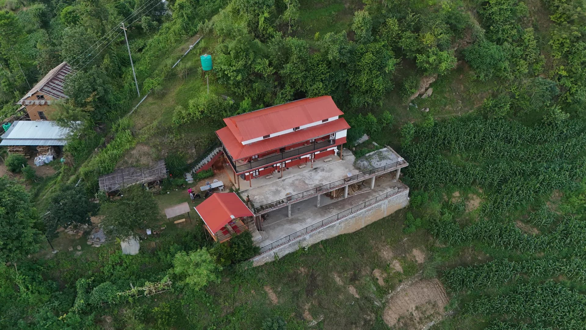 Aerial view of Baseri Farm Stay with outdoor terrace overlooking the valley