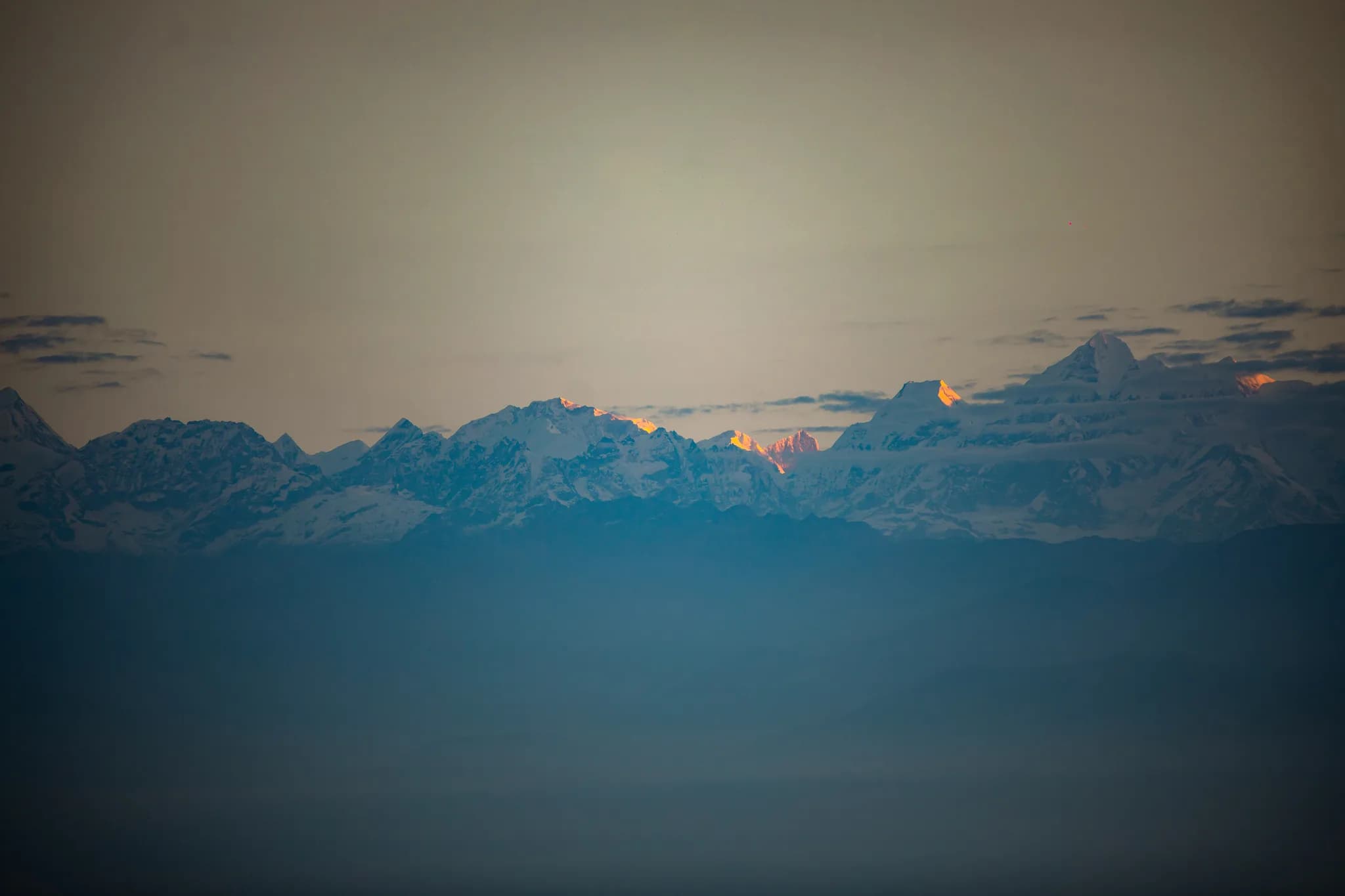 Witness nature's masterpiece as the first rays of sunlight light up the distant Himalayan horizon.